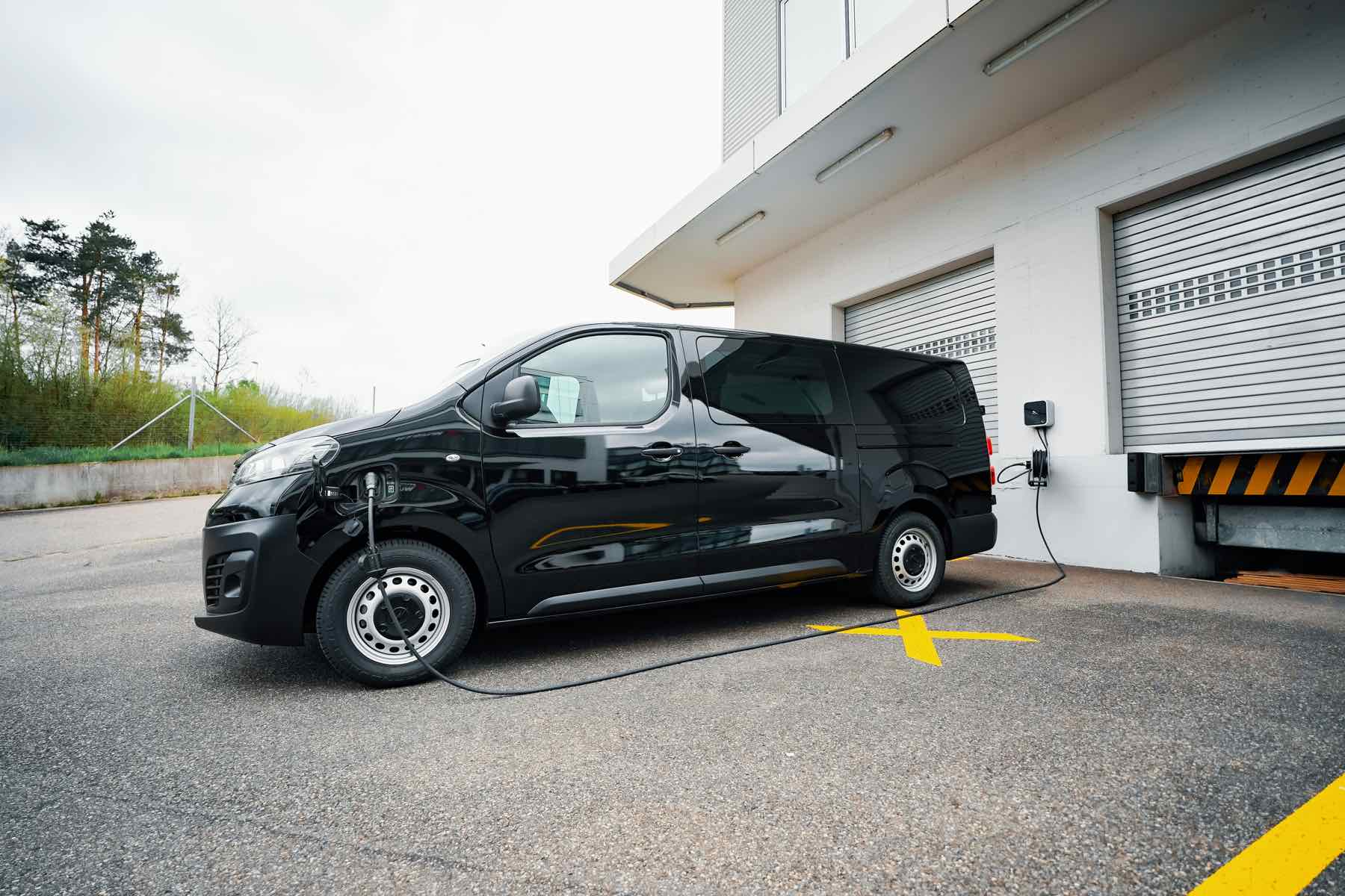 Elektrische bedrijfswagen bij laadpunt op private bedrijfslocatie